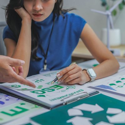 Businesswomen analyzing esg project, considering environmental conservation, social responsibility, and corporate governance
